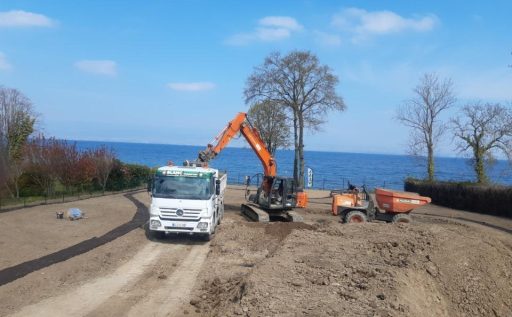 Des véhicules effectuent le terrassement au bord du Lac Léman